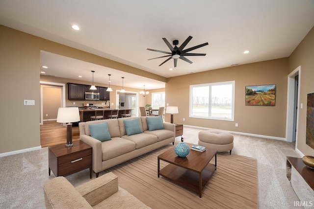 living area with ceiling fan, light colored carpet, recessed lighting, and baseboards