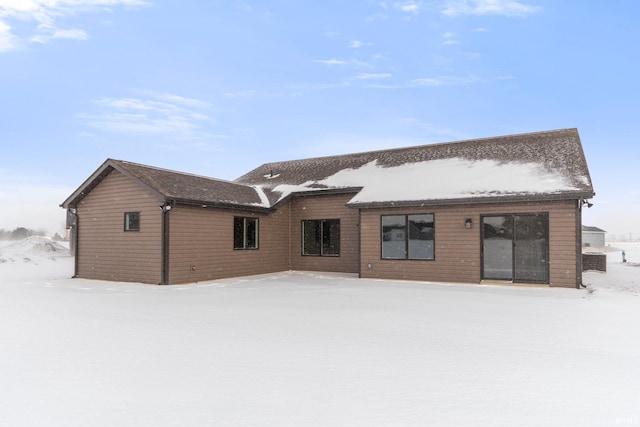 view of snow covered back of property