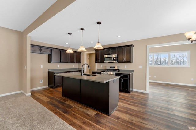 kitchen featuring stainless steel appliances, a sink, baseboards, and recessed lighting