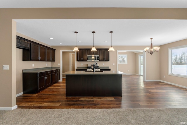 kitchen with stainless steel microwave, a sink, a chandelier, dark brown cabinets, and recessed lighting