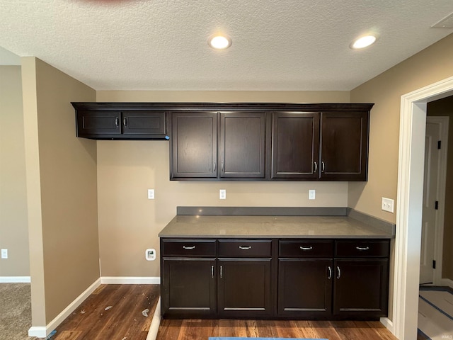 kitchen with dark brown cabinets, dark hardwood / wood-style floors, and a textured ceiling