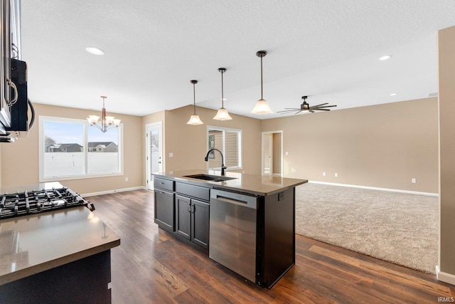 kitchen with appliances with stainless steel finishes, a sink, open floor plan, a chandelier, and a ceiling fan
