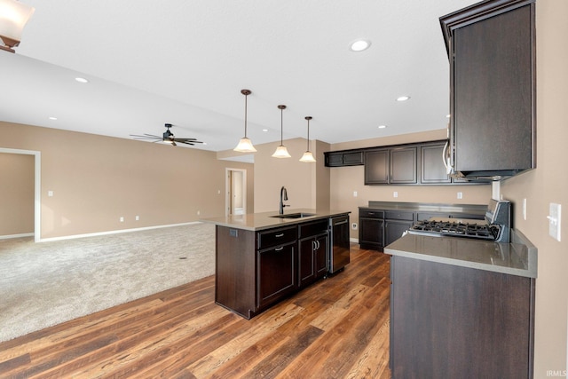 kitchen with a sink, gas range, a ceiling fan, dishwasher, and wood finished floors
