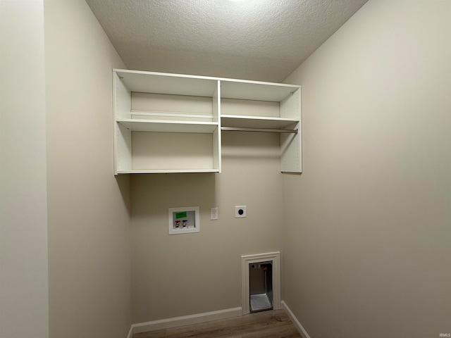 washroom featuring washer hookup, hardwood / wood-style floors, hookup for an electric dryer, and a textured ceiling