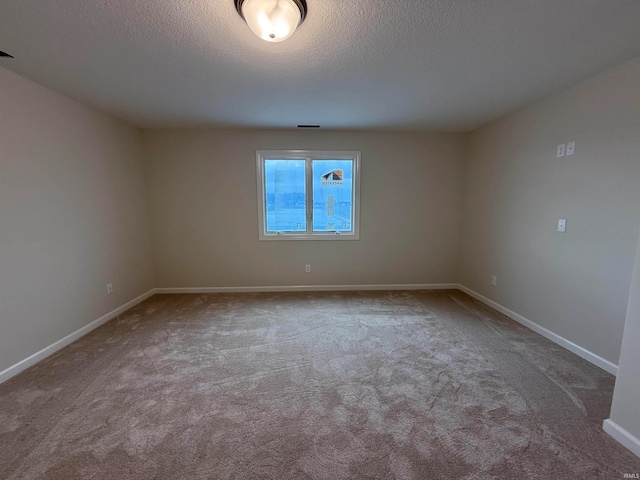 carpeted spare room featuring a textured ceiling