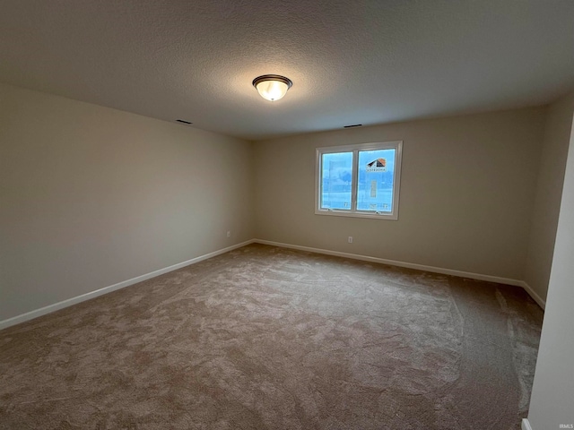 carpeted empty room featuring a textured ceiling