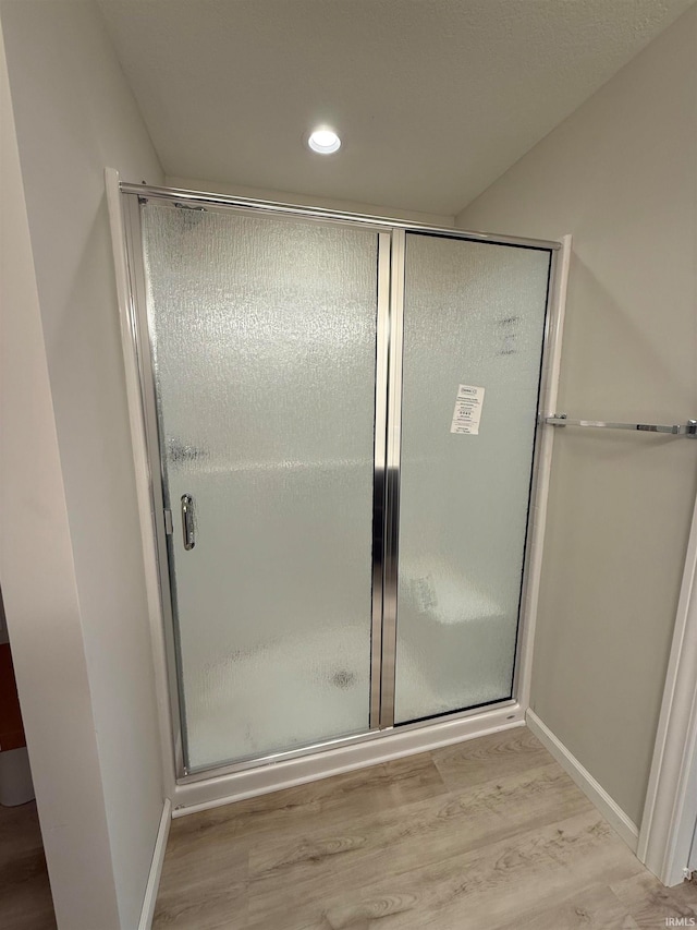 bathroom with walk in shower and wood-type flooring