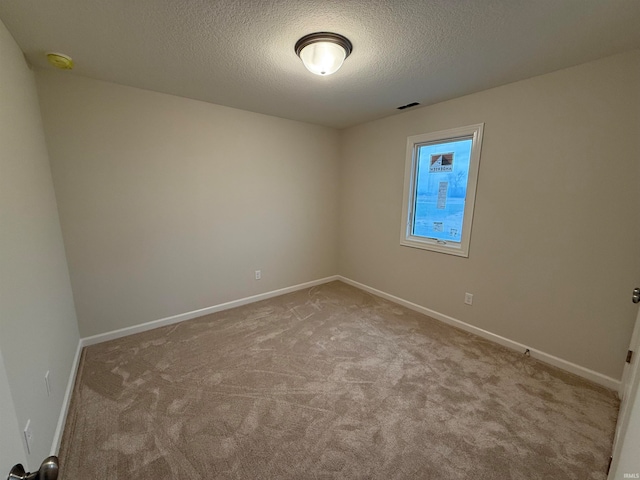 unfurnished room with a textured ceiling and light carpet