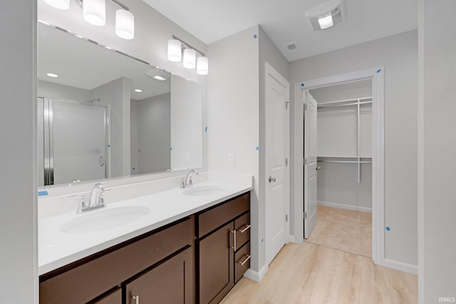 bathroom with vanity, hardwood / wood-style flooring, and a shower with door