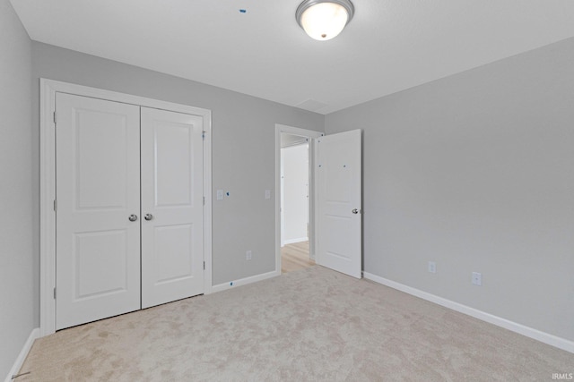 unfurnished bedroom with a closet and light carpet