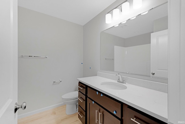 bathroom with toilet, hardwood / wood-style flooring, and vanity