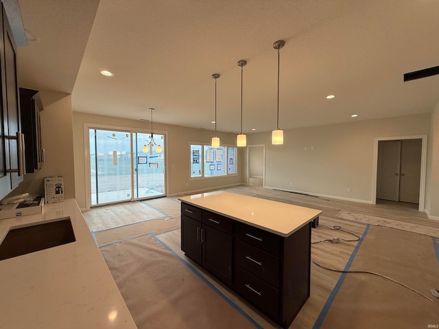 kitchen with pendant lighting, a kitchen island, and sink