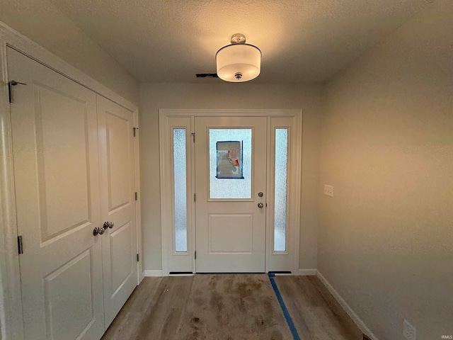 entrance foyer featuring a textured ceiling and light hardwood / wood-style floors