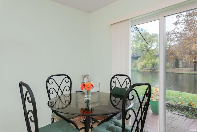 tiled dining room featuring a water view