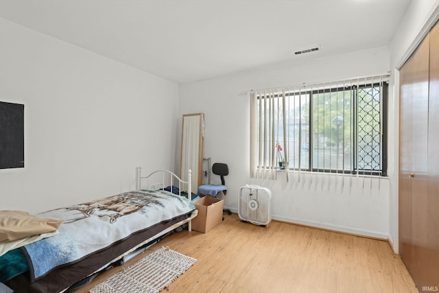 bedroom with light hardwood / wood-style flooring and a closet