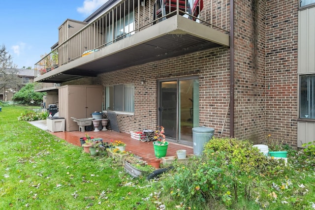 rear view of house featuring a patio, a yard, and a balcony