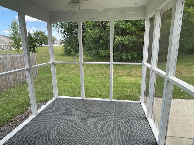 unfurnished sunroom featuring ceiling fan