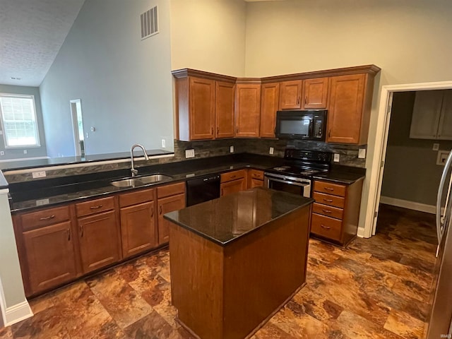 kitchen with black appliances, backsplash, a textured ceiling, sink, and a center island