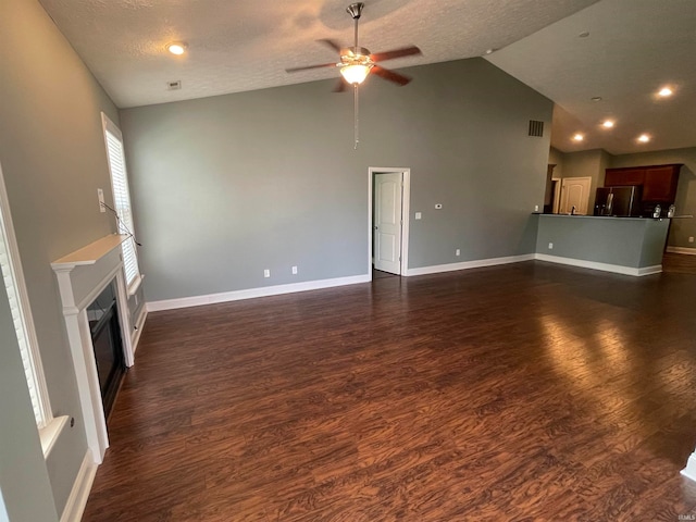 unfurnished living room with ceiling fan, dark hardwood / wood-style floors, a textured ceiling, and high vaulted ceiling