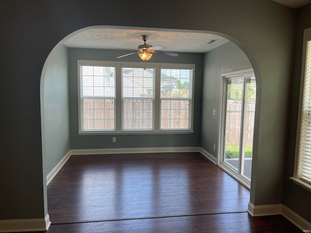 unfurnished room with dark wood-type flooring, a textured ceiling, and ceiling fan