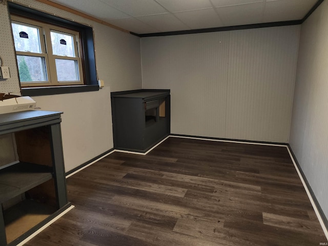 unfurnished room with dark hardwood / wood-style flooring, a drop ceiling, and ornamental molding