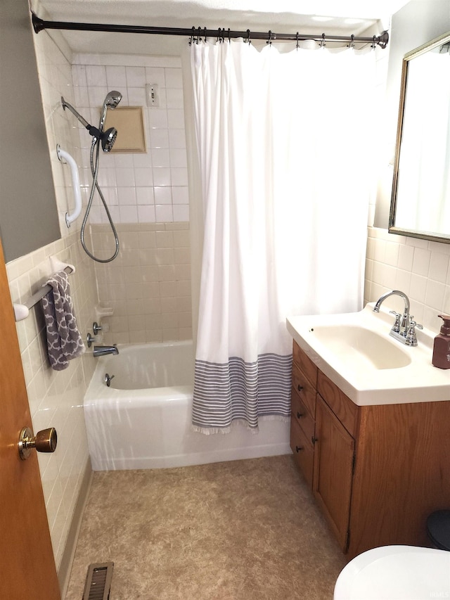 full bathroom with tile walls, vanity, toilet, and shower / tub combo with curtain