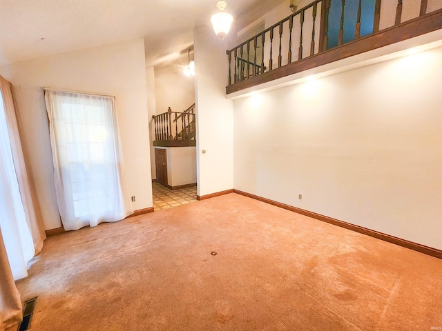 unfurnished dining area featuring carpet flooring and high vaulted ceiling