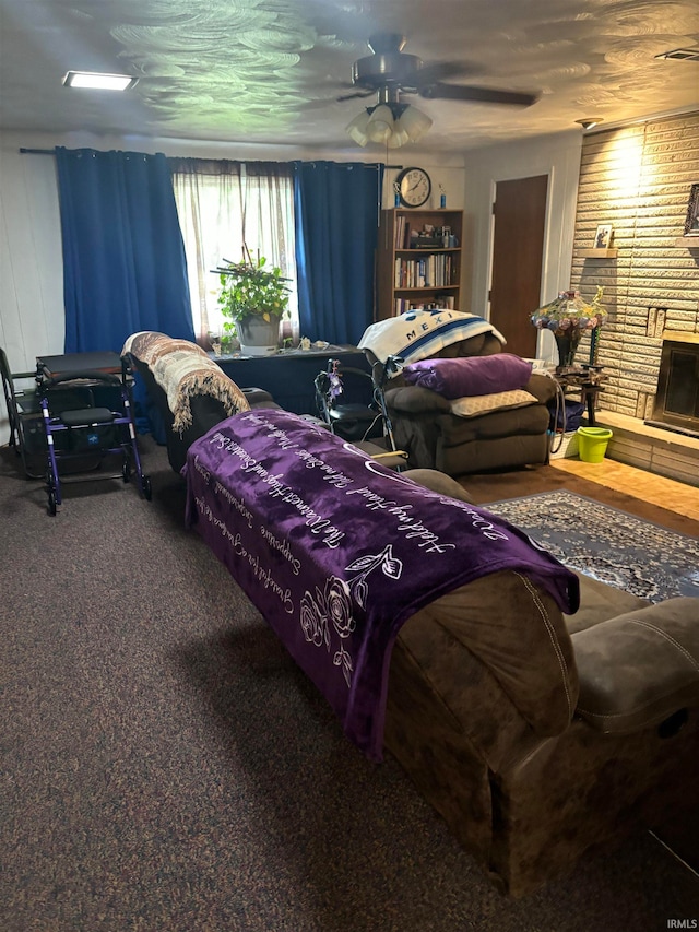 carpeted bedroom featuring a fireplace and ceiling fan