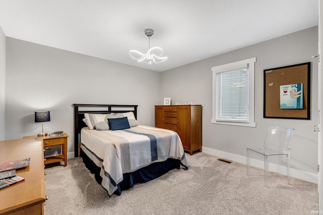 carpeted bedroom featuring a notable chandelier