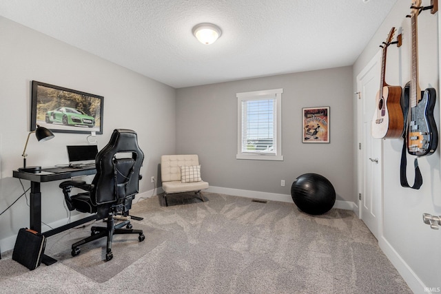 carpeted office space with a textured ceiling