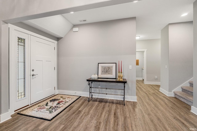 foyer entrance with light hardwood / wood-style floors and vaulted ceiling