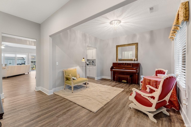 sitting room with wood-type flooring and a chandelier