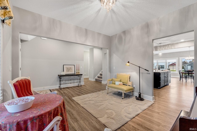 sitting room featuring hardwood / wood-style flooring, a textured ceiling, sink, and a notable chandelier