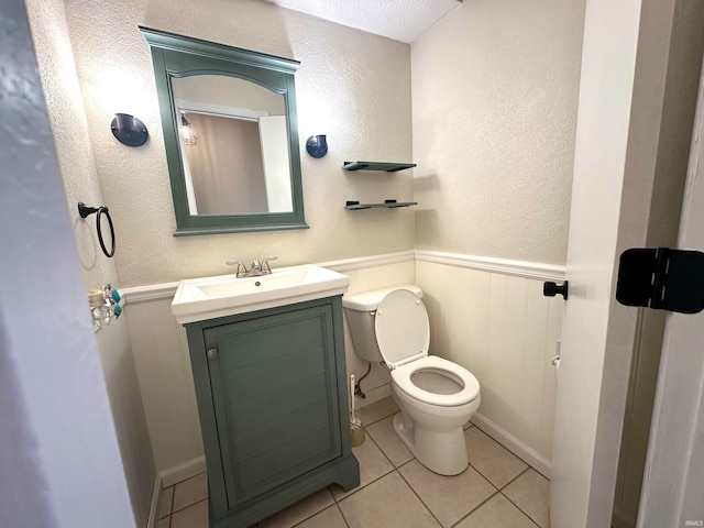 bathroom with vanity, a textured ceiling, tile patterned floors, and toilet