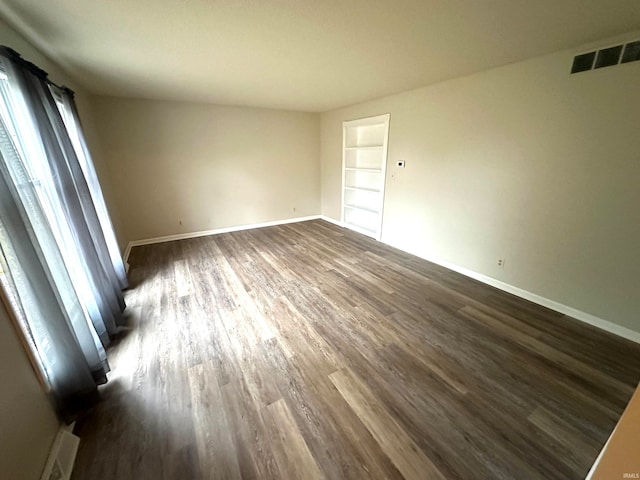 empty room with dark wood-type flooring