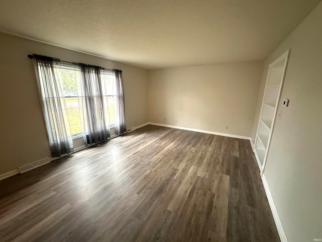 spare room with dark hardwood / wood-style flooring