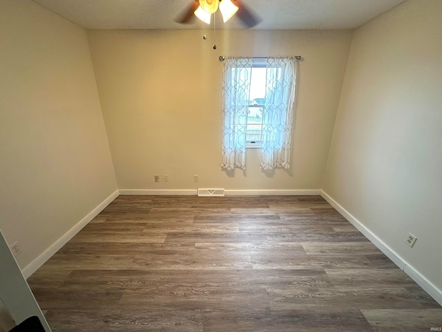 unfurnished room with dark wood-type flooring and ceiling fan