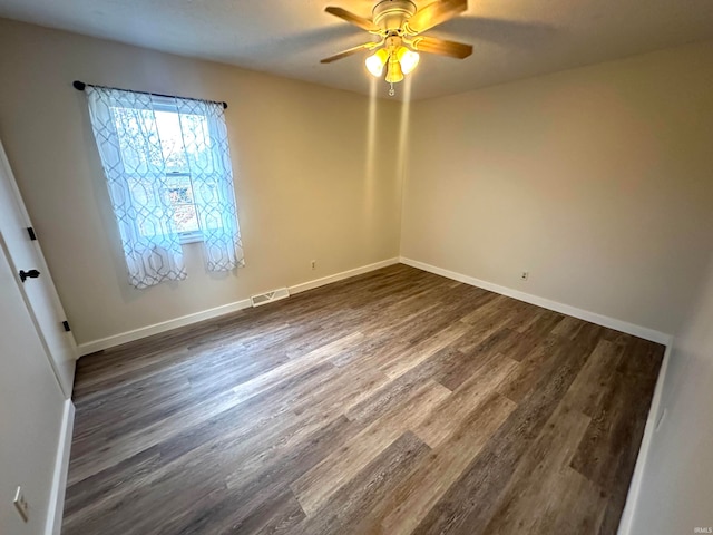 unfurnished room with dark hardwood / wood-style flooring and ceiling fan