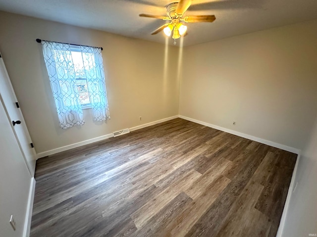 empty room featuring ceiling fan and dark hardwood / wood-style flooring