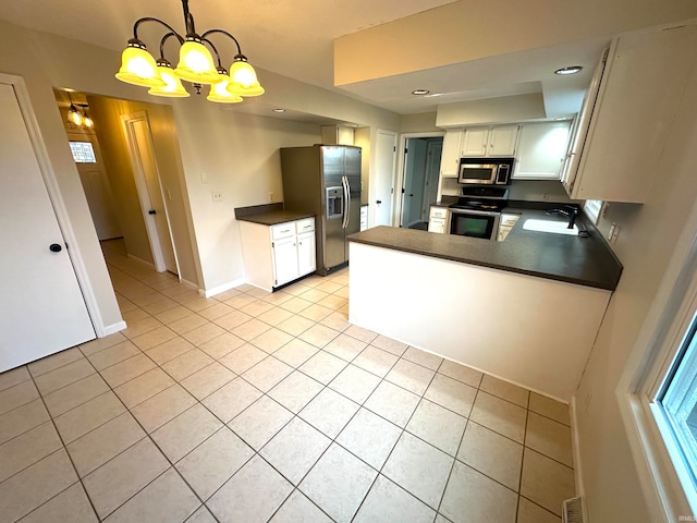 kitchen featuring pendant lighting, stainless steel appliances, light tile patterned flooring, and white cabinets