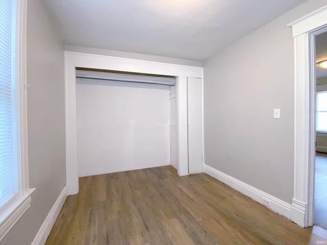 unfurnished bedroom featuring hardwood / wood-style floors and a closet