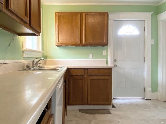 kitchen with white dishwasher, sink, and crown molding