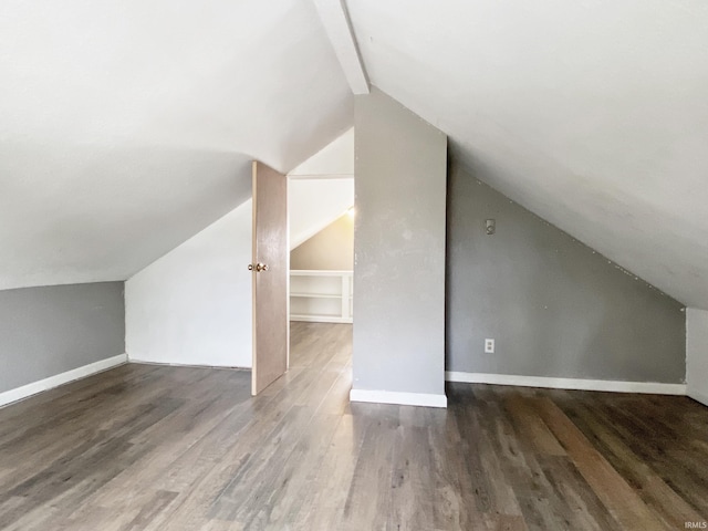 bonus room featuring dark hardwood / wood-style floors and lofted ceiling with beams