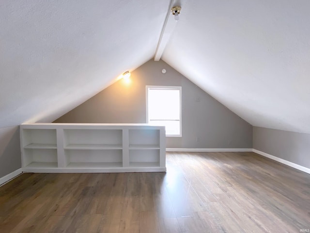 bonus room with lofted ceiling, a textured ceiling, and dark hardwood / wood-style flooring