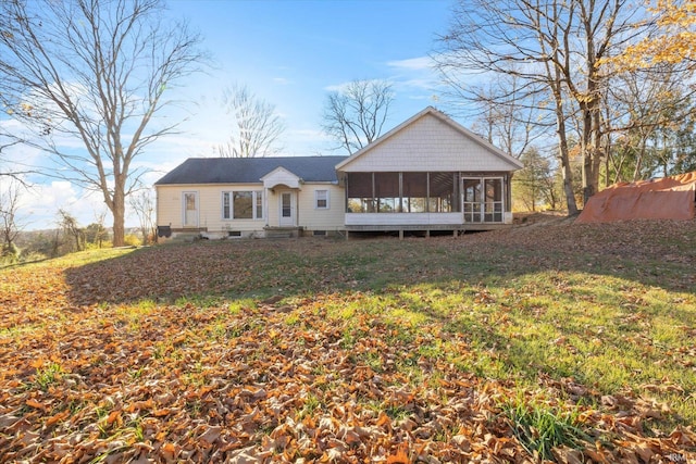 back of house featuring a lawn and a sunroom