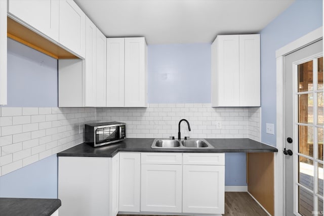 kitchen with white cabinets, decorative backsplash, plenty of natural light, and sink