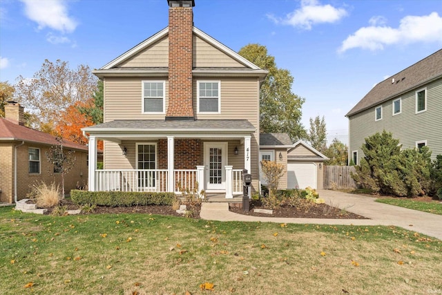 view of front property with an outbuilding, a garage, covered porch, and a front lawn