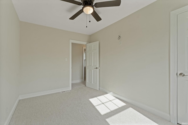 unfurnished room with ceiling fan and light colored carpet