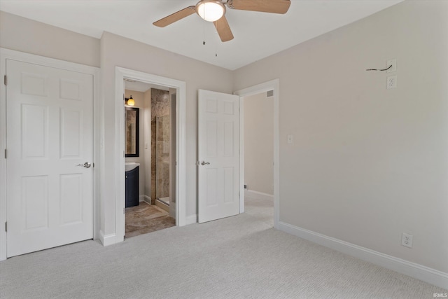 unfurnished bedroom with connected bathroom, light carpet, and ceiling fan