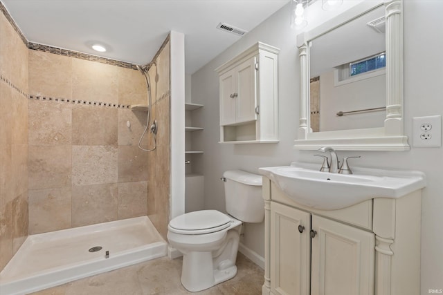 bathroom with tile patterned flooring, vanity, toilet, and a tile shower